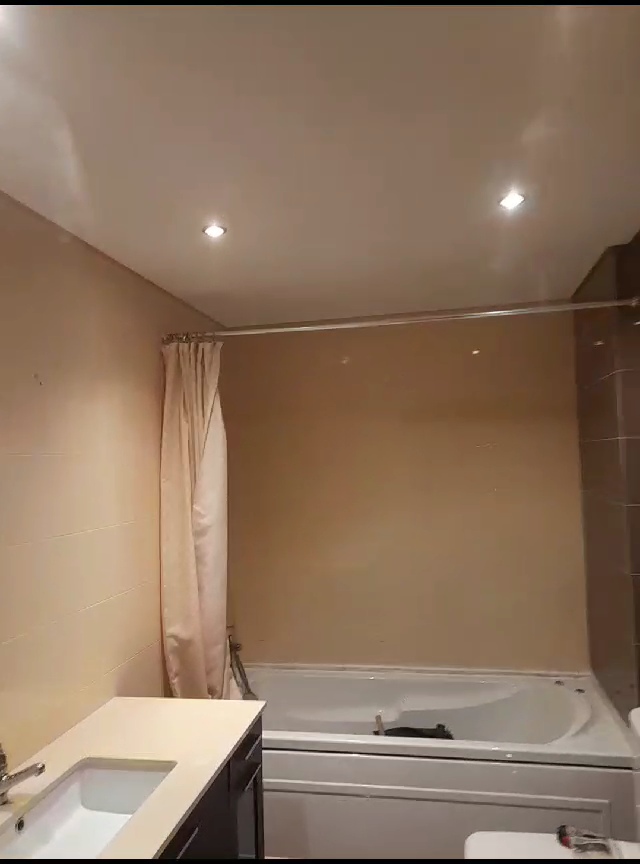 Casa de banho antiga com banheira e azulejo bege antes da remodelação