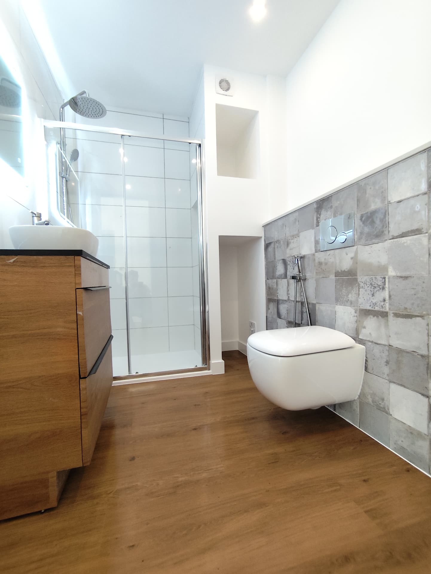 Casa de banho depois da remodelação, com base de duche e sanita suspensa