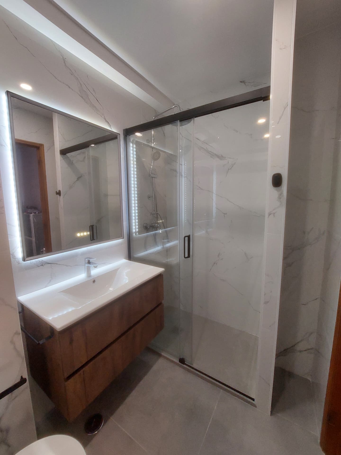 WC depois da remodelação, com espelho LED e móvel suspenso